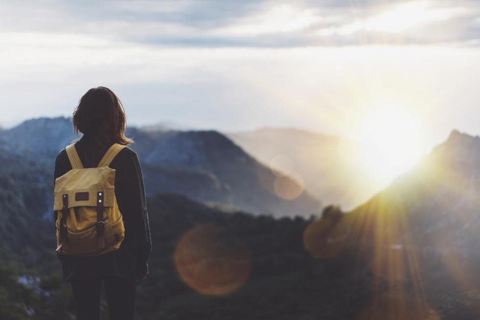 Die neue Generation ist viel auf Reisen: Bild: www.shutterstock.com/478859071/MariaSavenko Rucksacktouristin die gerade den Gipfel erreicht hat.