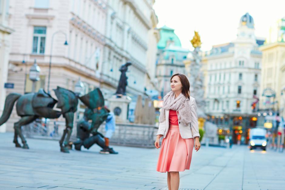 Junge Frau spaziert durch Wiener Altstadt.